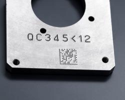 Pièce métallique gravée par micro-percussion d'un numéro de série et d'un code Datamatrix.