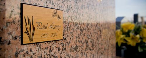 Plaque commémorative en bois réalisée à l'aide d'une machine à gravure mécanique funéraire.